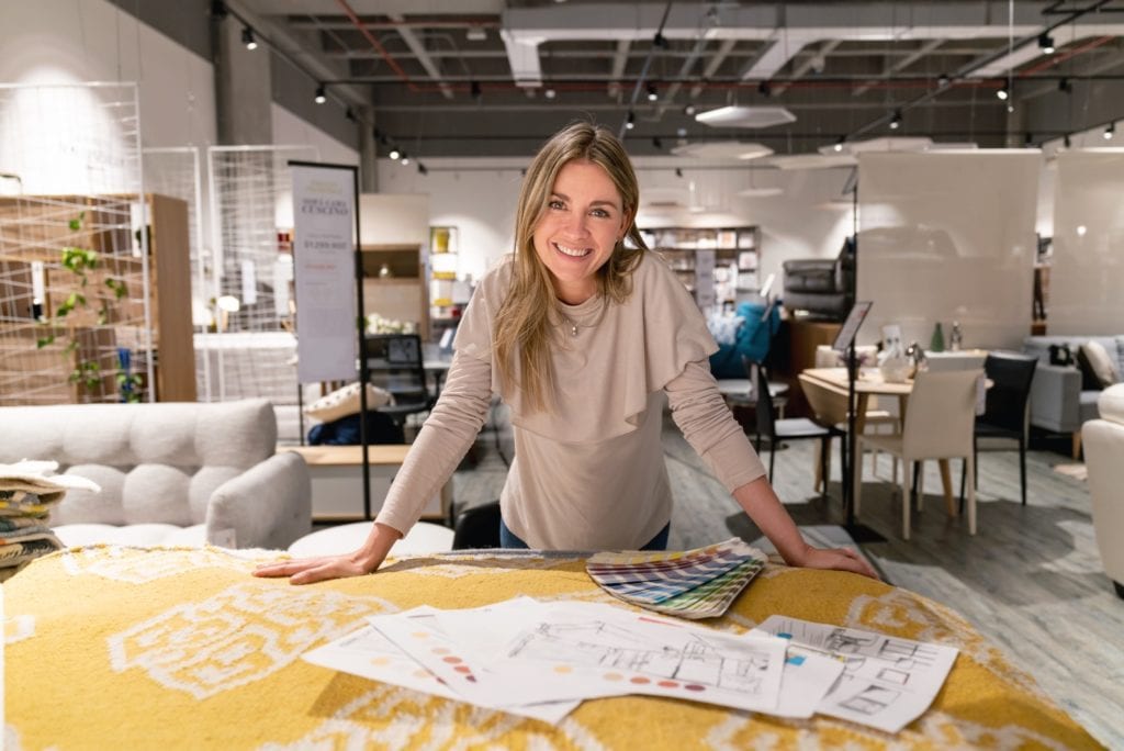 An interior designer showing her design creations in a furniture store