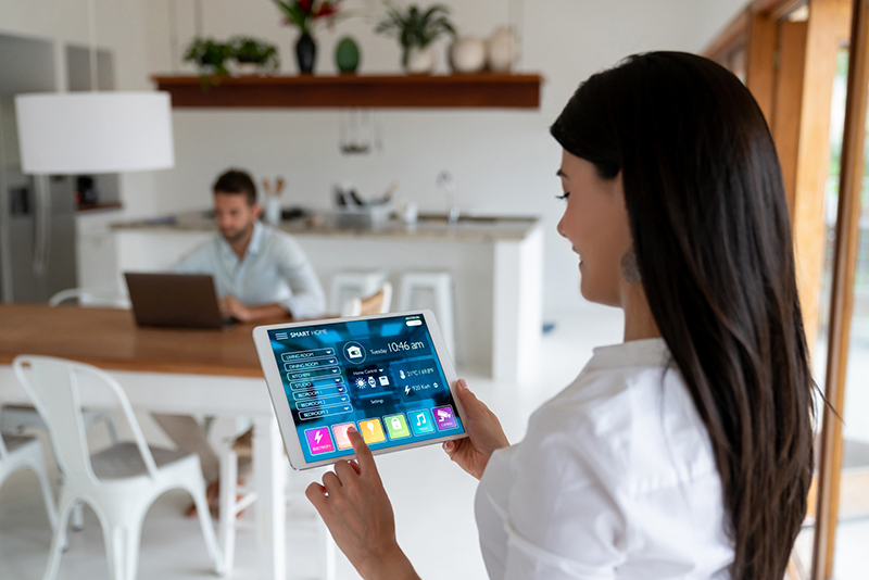 Woman setting up the intelligent home system on her tablet computer